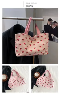 Macro detail of pink corduroy tote bag with red strawberry print and sturdy webbed handles