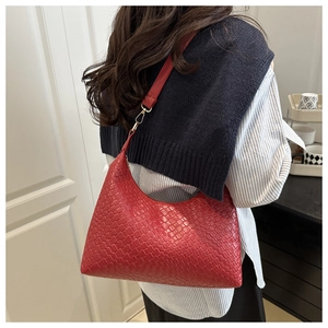 Detailed woven texture of red PU leather tote bag with elegant gold metal buckles