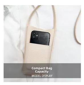 Nahaufnahme der cremeweißen Handytasche mit Litschi-Muster und Smartphone darin