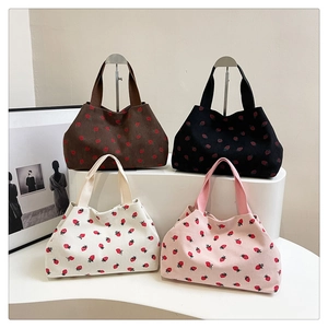 Detailed display of four corduroy strawberry print tote bags in diverse colors
