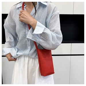 Detailansicht der roten Mini-Handytasche aus Leder mit Lychee-Struktur und vorderem Fach