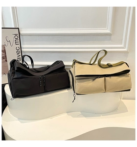 Dual-tone travel bags in black and khaki shown on a minimalist display stand