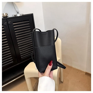 Gros plan détaillé du mini sac bandoulière en cuir noir à grain litchi et coutures