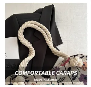 Detail of the woven floral tote bag with thick cotton rope handle on textured fabric