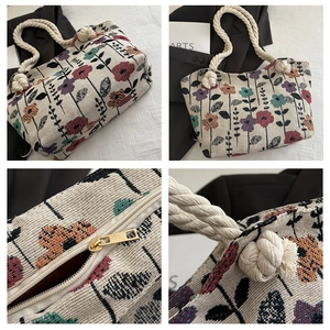 Macro detail of tapestry floral tote bag featuring thick cotton rope handles and metal zipper