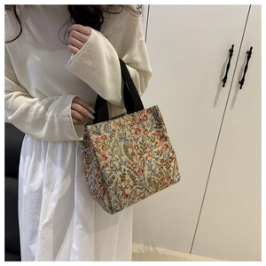 Detail of floral tapestry tote bag featuring vintage pink and blue blossom patterns