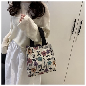 Detail of floral jacquard fabric and black webbing handle on a retro small tote bag