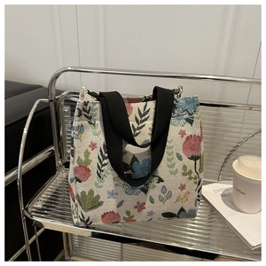 Close-up of floral canvas tote bag with colorful flower pattern and black woven handles