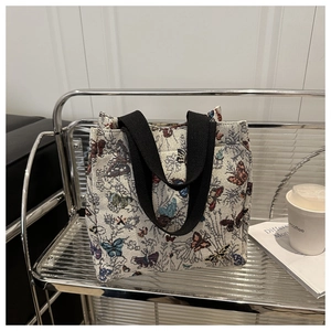 Close-up of a canvas tote bag with colorful butterfly patterns on a stylish shelf
