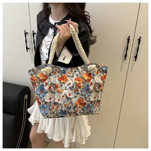 Detail of the colorful 3D floral appliqués and rustic hemp rope handle on the tote bag