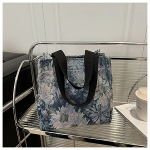 Close-up of blue and white daisy jacquard fabric texture on a retro tote handbag