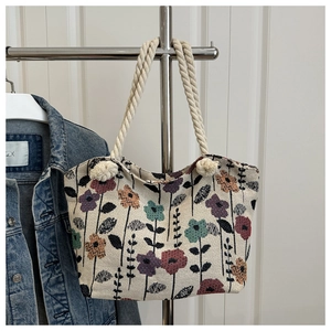 Detailed close-up of a floral print tote bag with thick woven rope handles and vibrant flowers