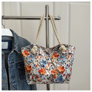 Detail of floral embroidery tote bag with cream cotton rope handles for beach vacation