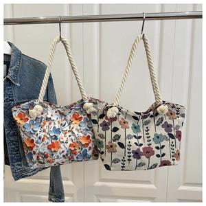 Detail of floral tote bags featuring 3D flower embroidery and woven cotton rope handles