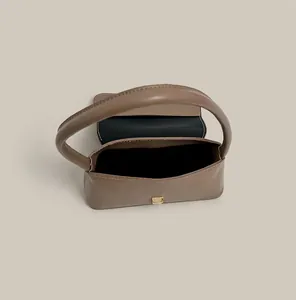 Detail of a brown crescent bag showing the internal compartment and gold buckle