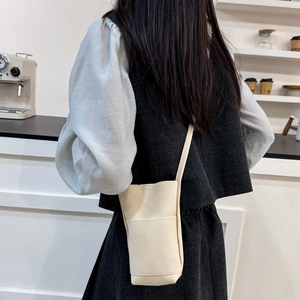Petit sac à bandoulière beige minimaliste pour téléphone avec texture cuir en café