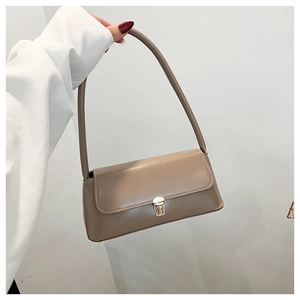 Detail of khaki leather baguette bag showing golden square clasp and shoulder strap