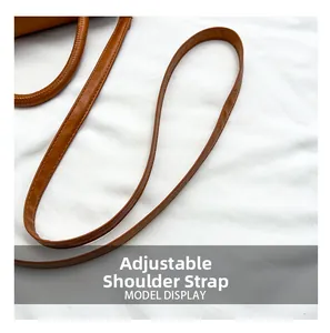 Detailed close-up of the adjustable brown leather shoulder strap with precise stitching