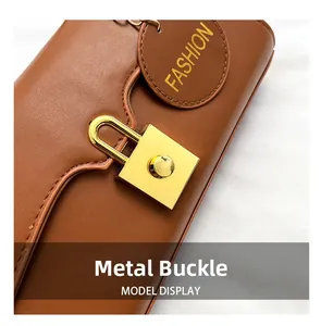 Close-up of a gold rectangular buckle on a brown leather shoulder bag with a fashion tag