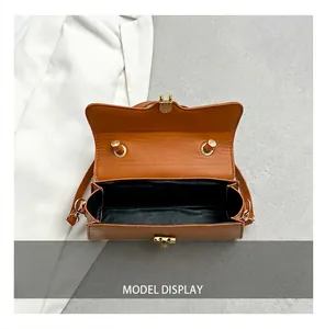 Detail view of caramel brown faux leather shoulder bag with spacious black lined interior