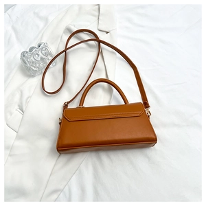 Detail view of a vintage brown leather crossbody bag with rounded top handle and slim strap