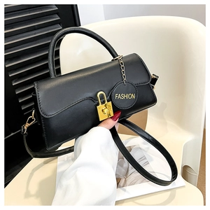 Détail du sac à bandoulière boîte noire avec fermoir doré et étiquette tendance
