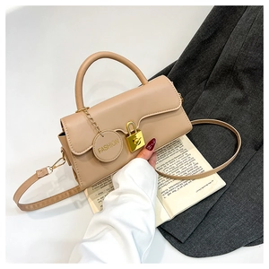 Detail view of stylish matte leather handbag with gold buckle and fashion tag