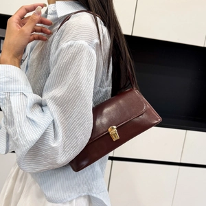 Classic burgundy leather baguette shoulder bag with gold hardware buckle and minimalist design