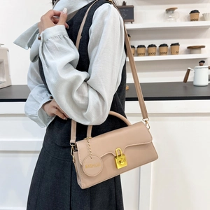 Sac à bandoulière minimaliste en cuir beige avec fermoir doré et étiquette mode