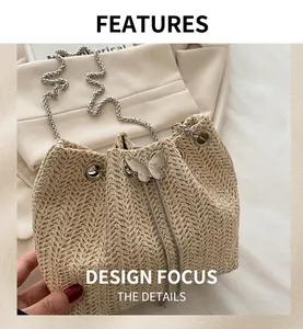 Detail of woven bucket bag featuring silver chain strap and metal butterfly ornament