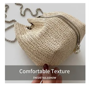 Detailed close-up of woven bucket bag featuring pearl pendant and metal chain strap