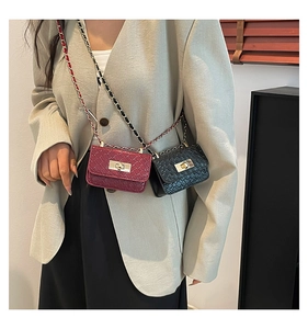 Close-up of mini quilted crossbody bags in burgundy and black with gold chain straps