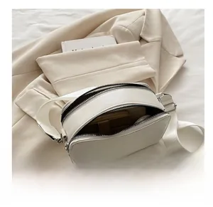 Detailed interior view showing storage capacity of a white double-zipper camera bag