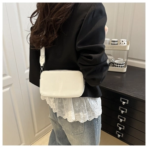 Detail of white rectangular camera bag with adjustable strap and premium stitching