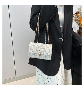 Détail du sac bandoulière en tweed avec chaîne dorée et boucle métallique élégante