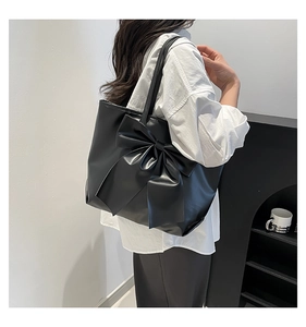 Vue détaillée arrière du grand sac cabas noir avec nœud latéral porté par un mannequin