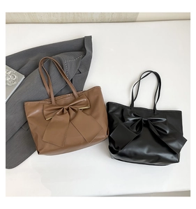 Vue à plat de grands sacs fourre-tout marron et noir avec de gros nœuds pour le quotidien