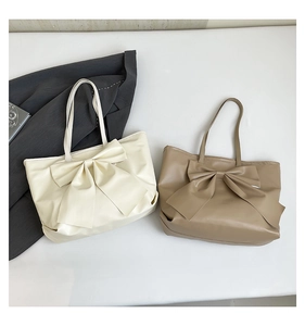 Vue détaillée des sacs cabas avec nœuds géants en similicuir crème et kaki élégant