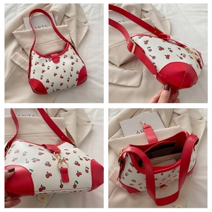 Detail view of cherry print shoulder bag showing interior lining and gold hardware