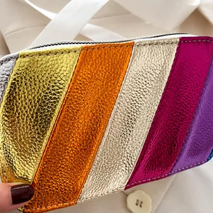 Close-up of metallic rainbow leather camera bag with grainy texture and white zipper detail