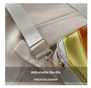 Detail of adjustable gold buckle and white lychee texture leather on colorblock camera bag