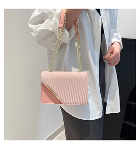 Detail of pink crossbody bag featuring chain strap and textured diagonal quilting pattern