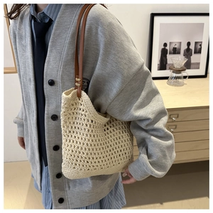 Close-up of the beige hand-woven shoulder bag with delicate hollow mesh design