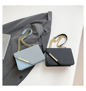 Détail de sacs à chaîne bleu clair et noir avec rabat diagonal et barrette métallique dorée