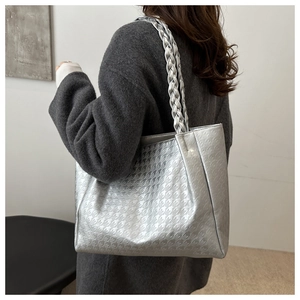 Dettaglio della borsa shopper argento con motivo pied-de-poule e tracolla intrecciata