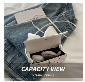 Internal view of a white polka dot crossbody bag showing space for cosmetics and earphones