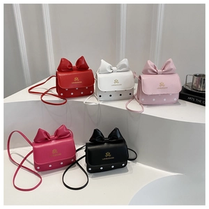 Detailed display of five colorful mini crossbody bags with large bows and polka dot patterns