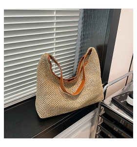 Detailed close-up of woven straw tote bag texture and brown leather shoulder strap