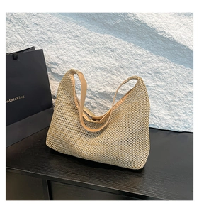Detail of hollow mesh woven pattern on beige hobo shoulder bag with textured surface