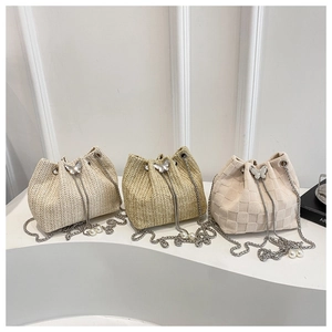 Detailed macro view of woven bucket bags with silver butterfly and pearl chain accessories